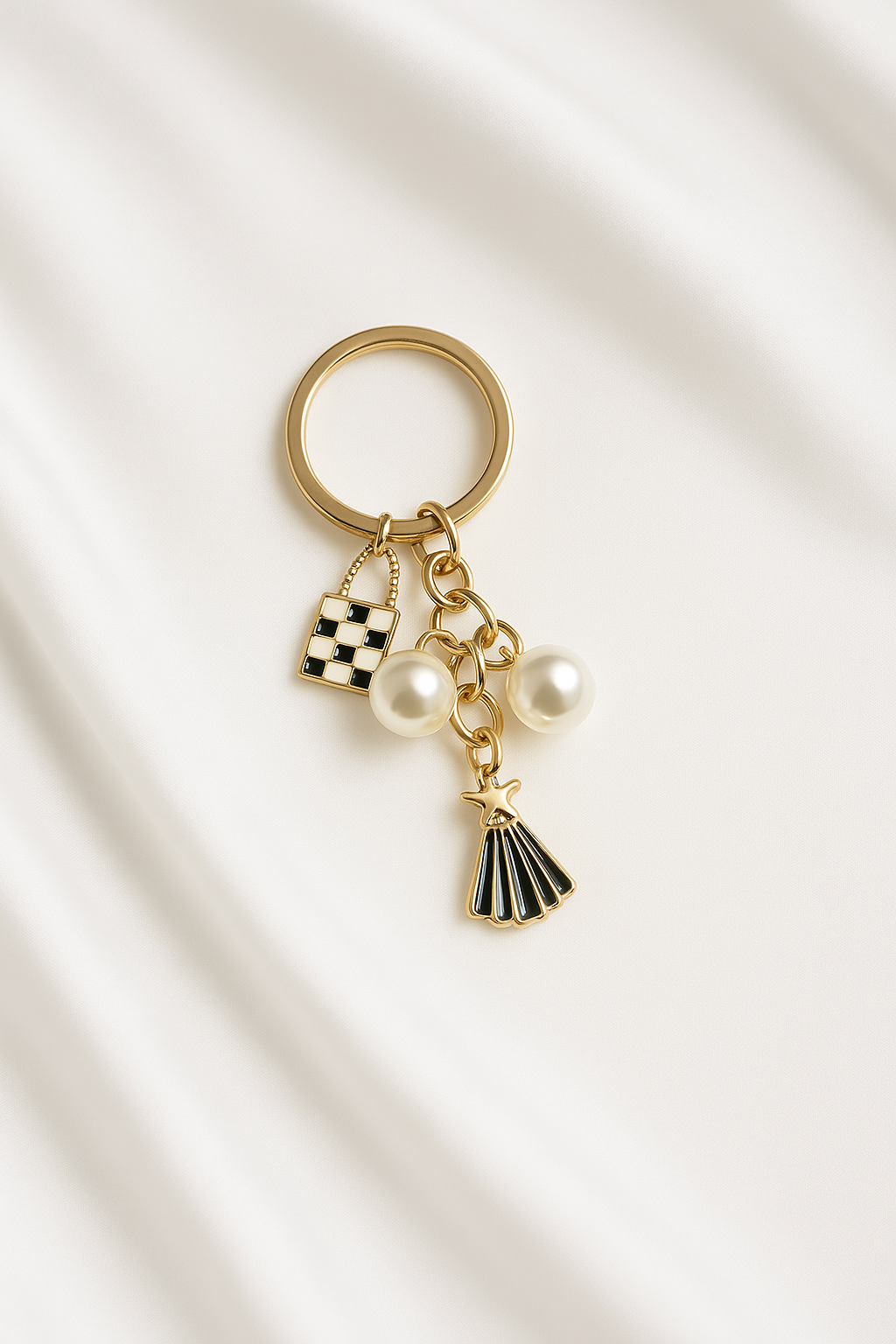 Gold keychain with charms on a light beige background